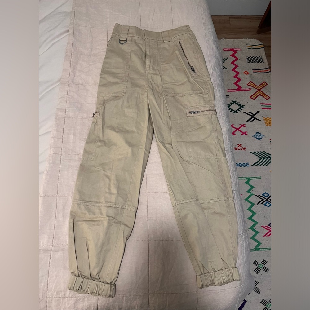 Aritzia TNA light tan cargo pants with zippers.